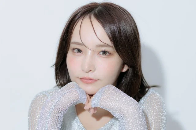 手を添えてほほえむミディアムヘアの女性モデル